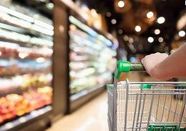 Una persona con un carrito de la compra en un supermercado.
