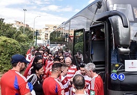 Aficionados del Granada, en torno a uno de los cinco autobuses que viajan a Málaga.