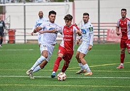 El jugador local, Avilés, disputa el esférico ante Juanma Porro.