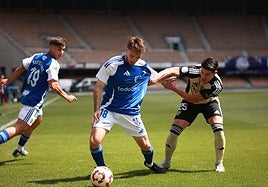 El linarense Teté agarrando al jerezano Ricky en la disputa de un balón en el centro del campo.