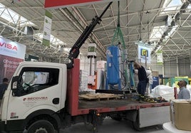 Operario utiliza una grúa hidráulica para bajar maquinaria