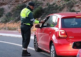 Un agente de la Guardia Civil de Tráfico practica un test de alcohol a un vehículo en El Cañarete.