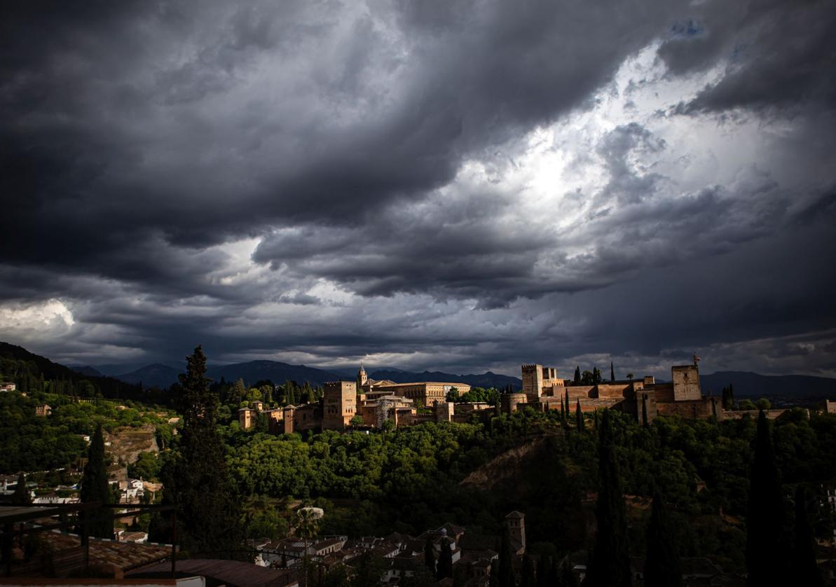 Los nubarrones negros sobre la Alhambra de Granada ayer por la tarde.