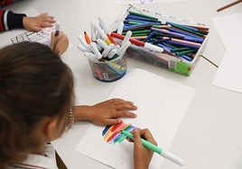 Una niña hace un dibujo en clase.