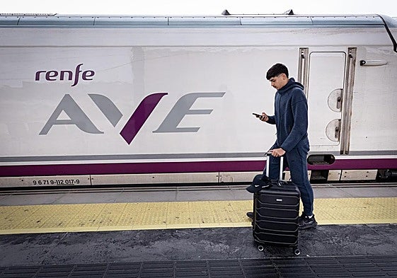 Un viajero mira su teléfono.