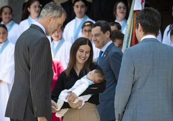 Felipe VI saluda a un bebé durante su visita a Granada.