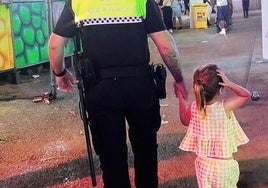 La pequeña, de la mano del agente que le ayudó a encontrar a su familia.