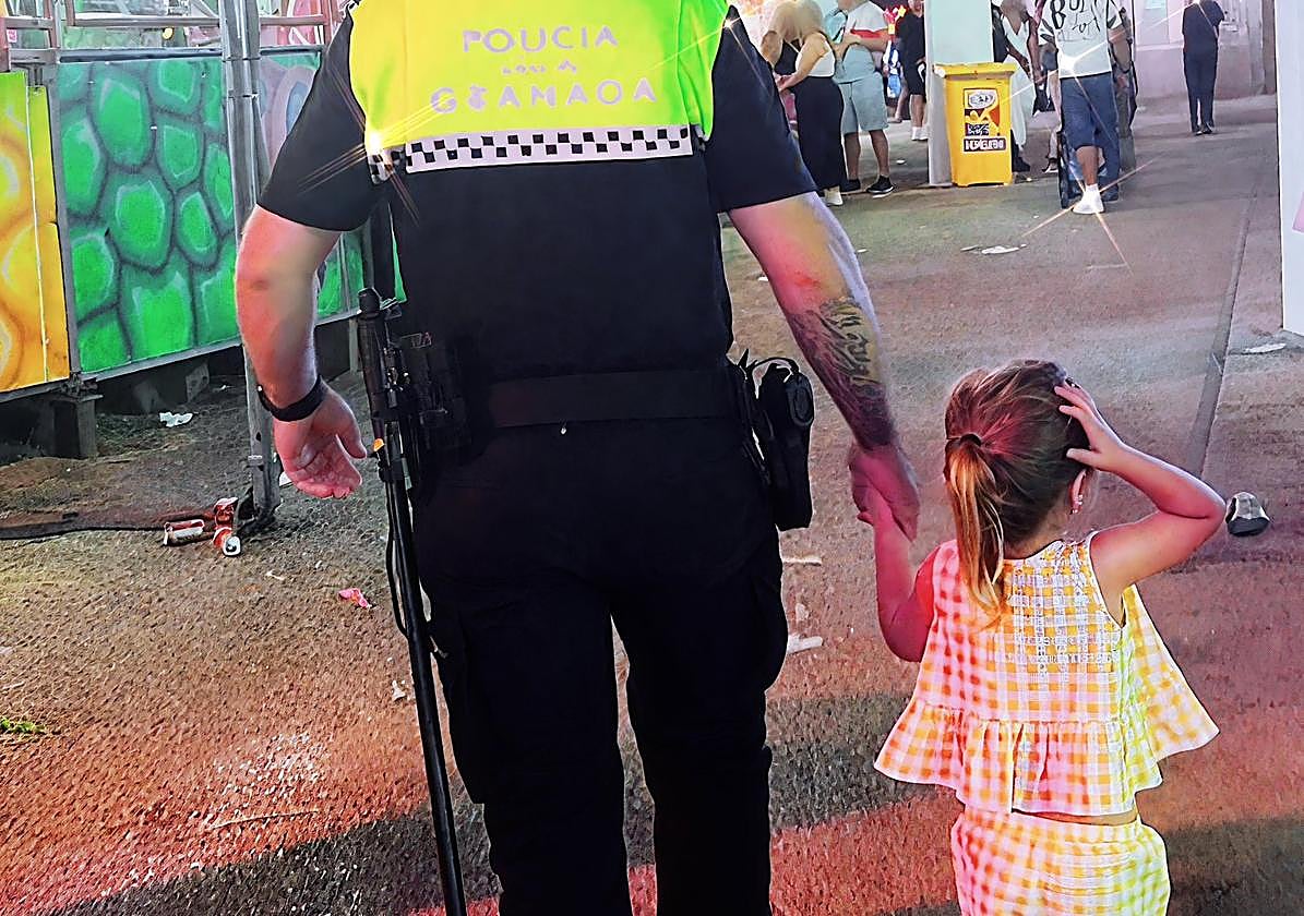 La pequeña, de la mano del agente que le ayudó a encontrar a su familia.