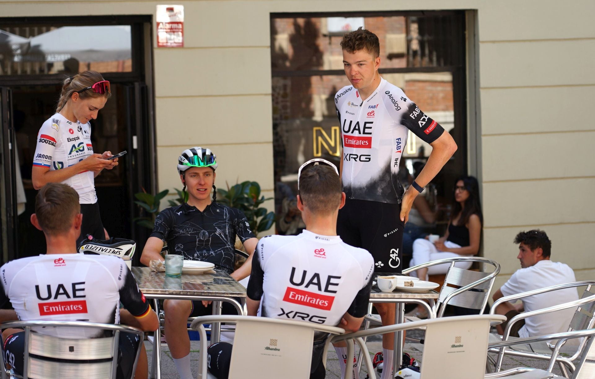 Tadej Pogagar, junto a miembros de su equipo UAE Emirates en una céntrica cafetería de Granada.