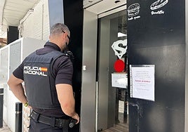 Un policía en la puerta de uno de los establecimientos afectados.