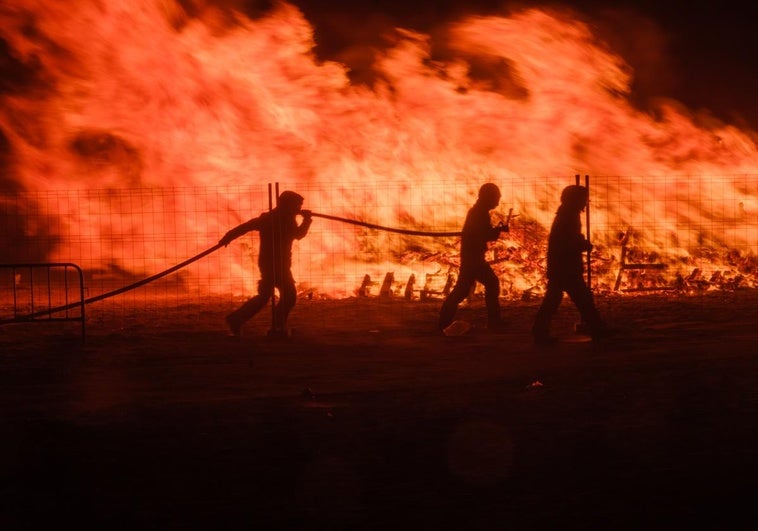 Bomberos actúan para apagar la hoguera en la playa del Cable de Motril