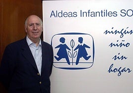 Juan Belda junto a un cartel de la organización