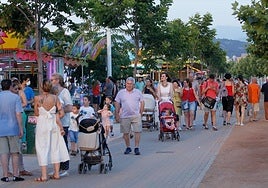 Varios vecinos paseando por el recinto ferial del barrio granadino.