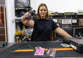 Cristina, de Armería Orantes, muestra los espráis pimienta que vende en su local.