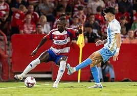 El rojiblanco Martin Hongla protege el balón ante el Málaga en Los Cármenes.