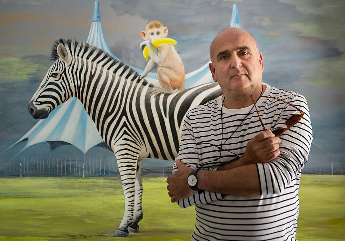 Juan Vida junto a una de las obras de ambiente circense que pinta en su estudio de Pinos Genil.