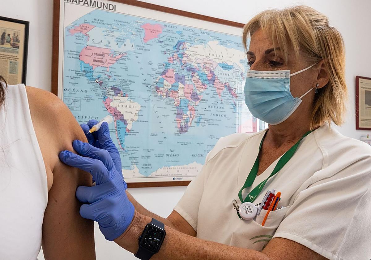 Una enfermera vacuna a una mujer en el Centro de Vacunación Internacional.