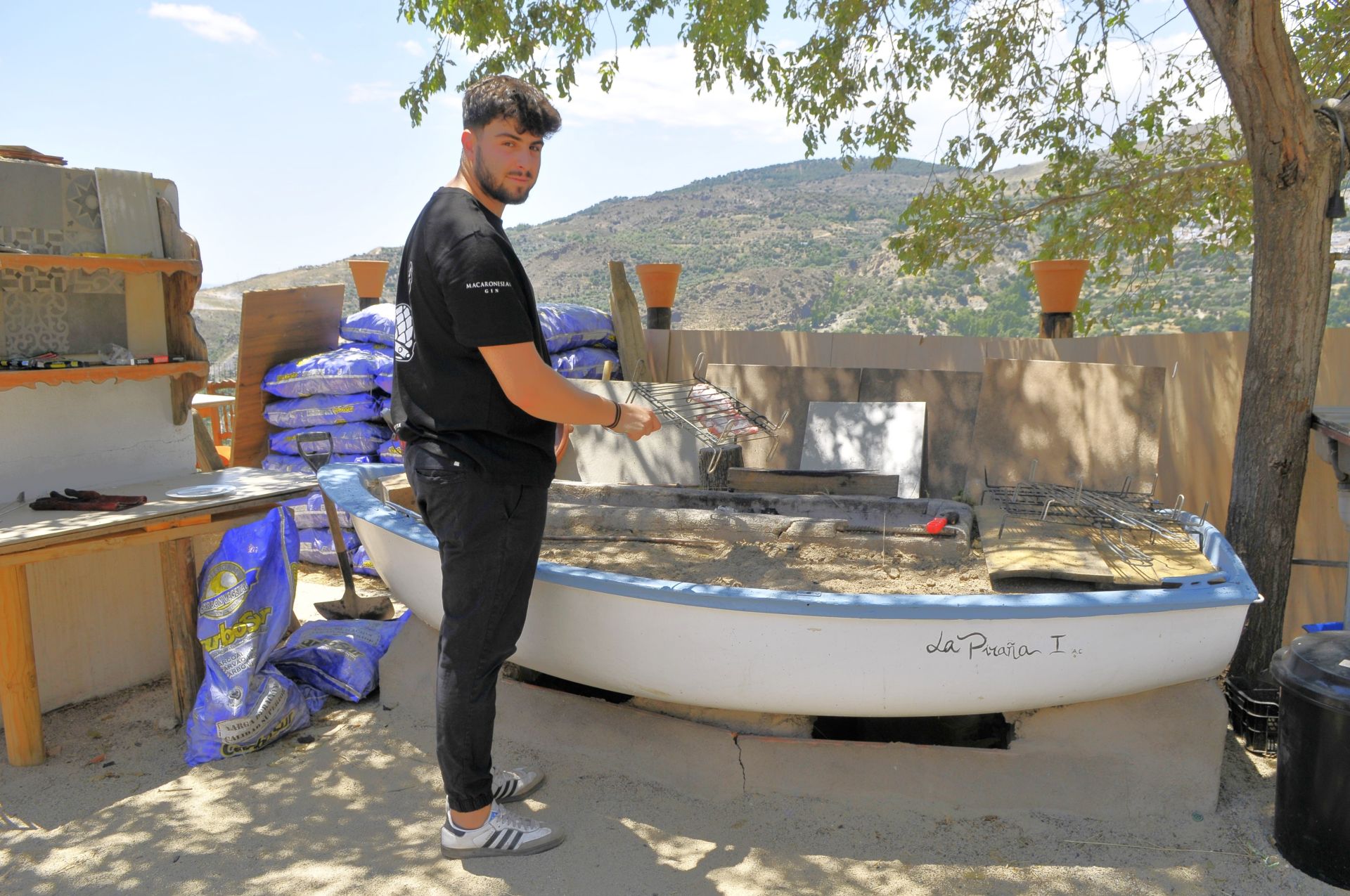 Espetos de sardinas asadas y carne a la brasa en una barca a 1.200 metros de altitud en Granada