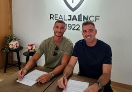 El jugador jienense firmando su renovación junto a Fran Anera.