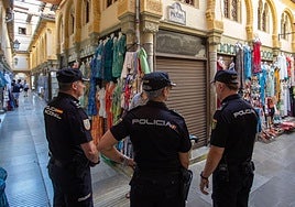 Agentes de la Policía Nacional charlan con un comerciante en la Alcaicería.