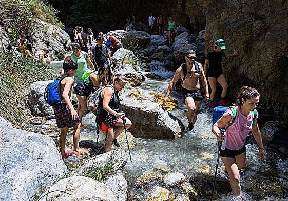 Senderistas recorren la ruta de Los Bolos por el río Dúrcal.
