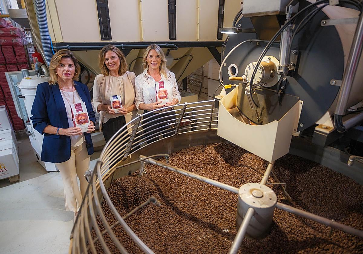 Elisa, Rosa y Ana Carmona, frente a los granos de café en la factoría de la Costa.