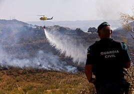 Un helicóptero del Infoca trabajando ayer sobre el terreno en Jun.