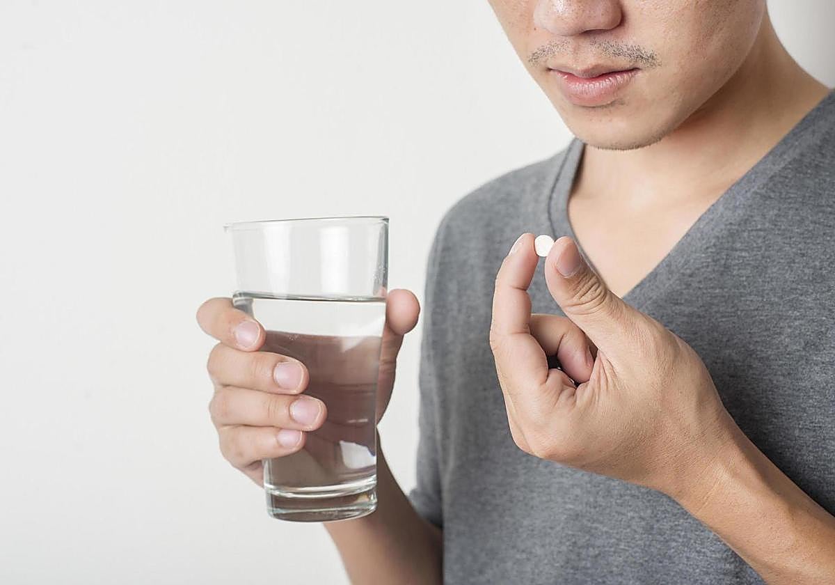 Hombre tomando una pastilla