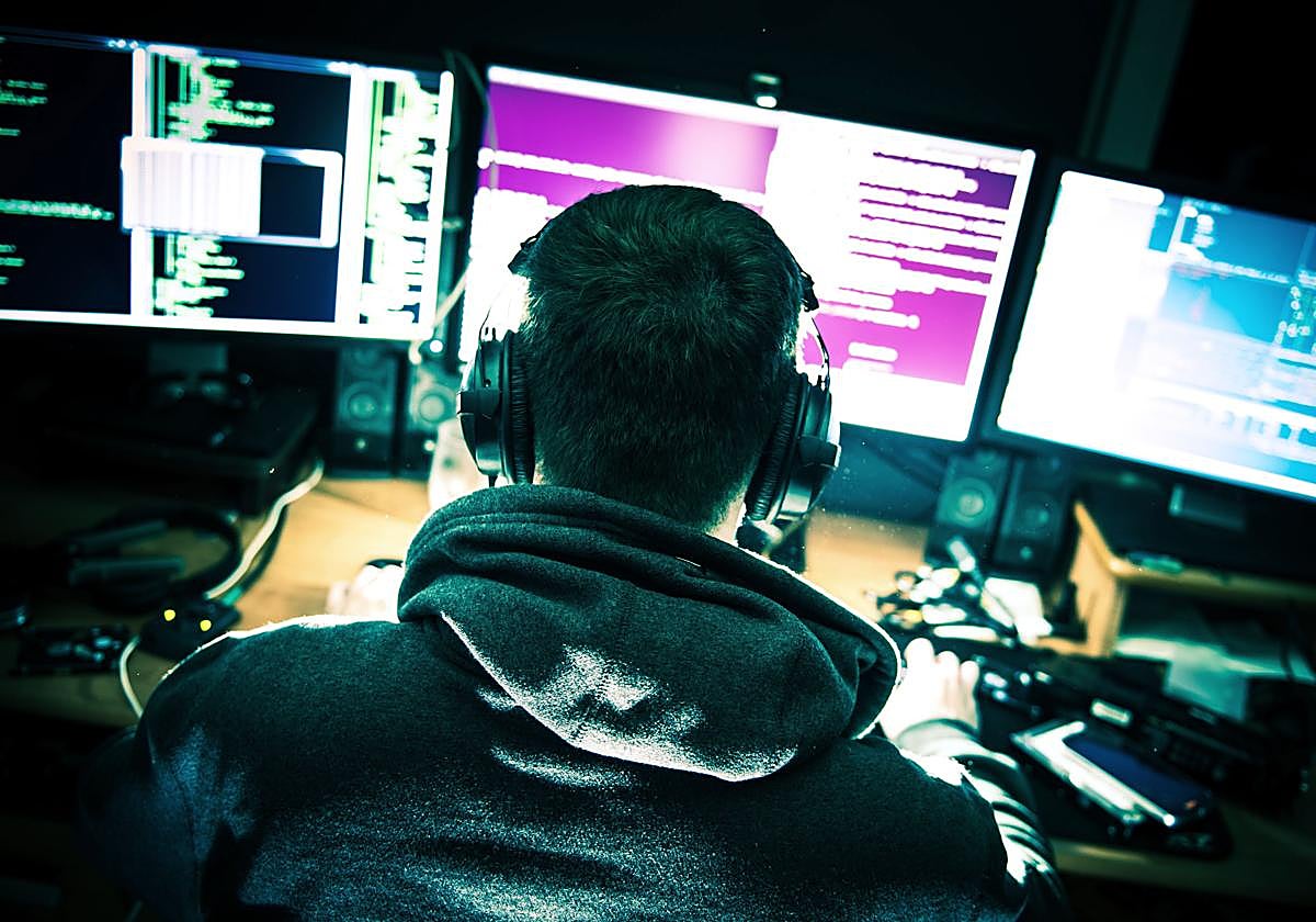 Un joven, ante varias pantallas de ordenador.