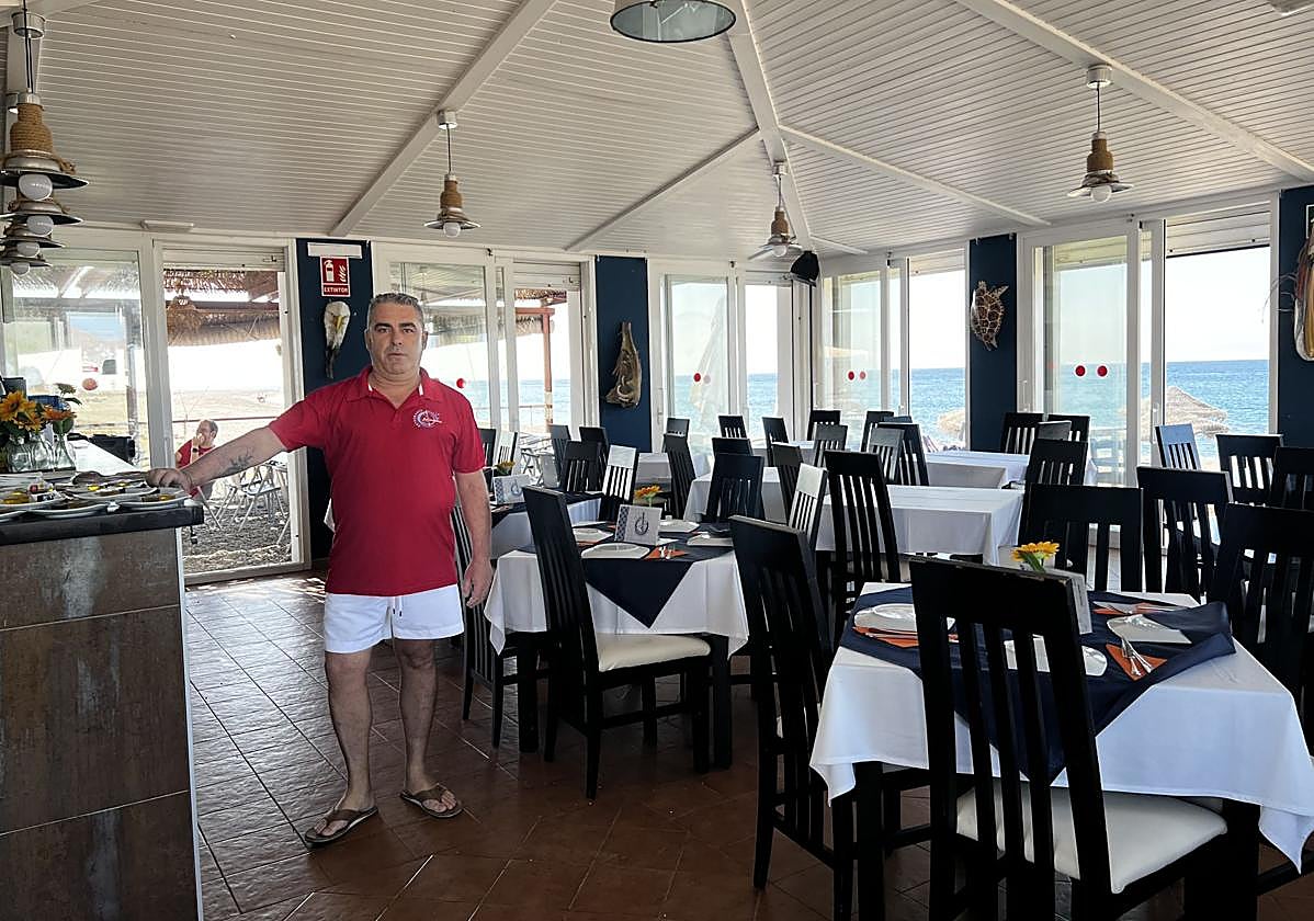 Juan Carlos en su establecimiento con las mesas vacías.