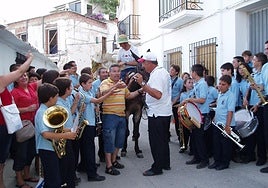 Un hombre reparte mantecados y anís por las calles de Bérchules con un mulo.