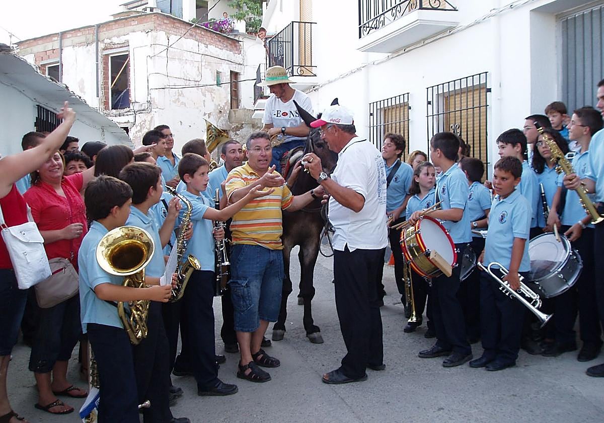 Un hombre reparte mantecados y anís por las calles de Bérchules con un mulo.