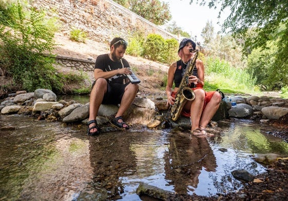 Mario y Lorena, tocando el saxo y el melódica en el Darro.