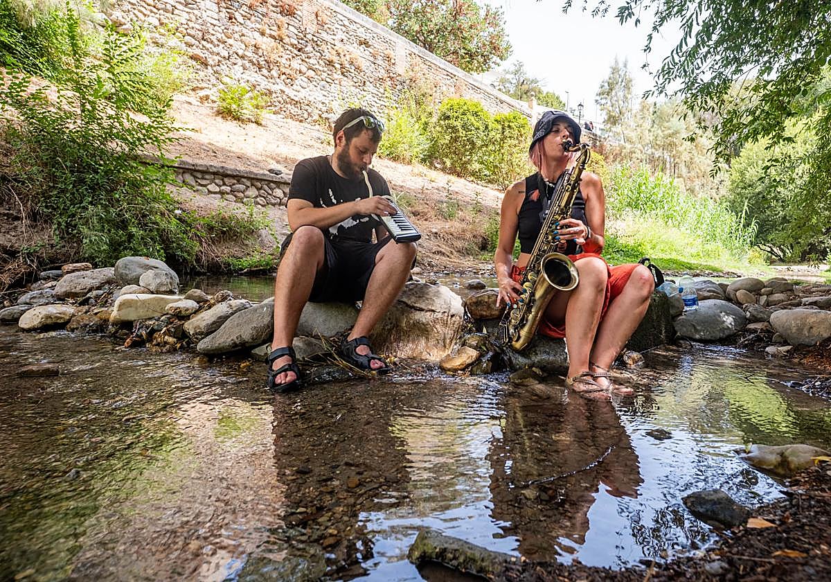 Mario y Lorena, tocando el saxo y el melódica en el Darro.
