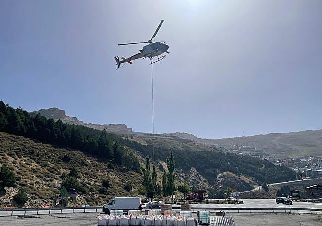 El helicóptero recoge los materiales en el helipuerto de la carretera de Sierra Nevada.