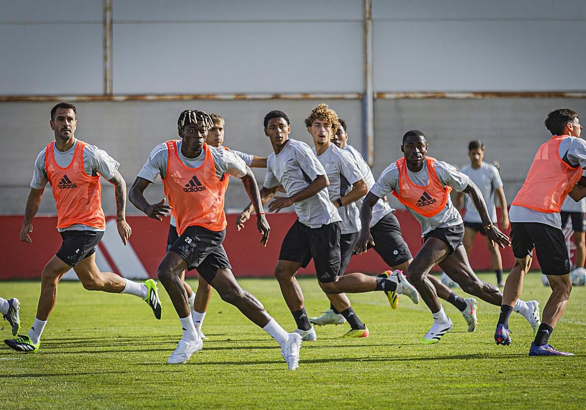 Varios futbolistas del primer equipo practican situaciones de ataque y defensa con centros laterales durante una sesión.