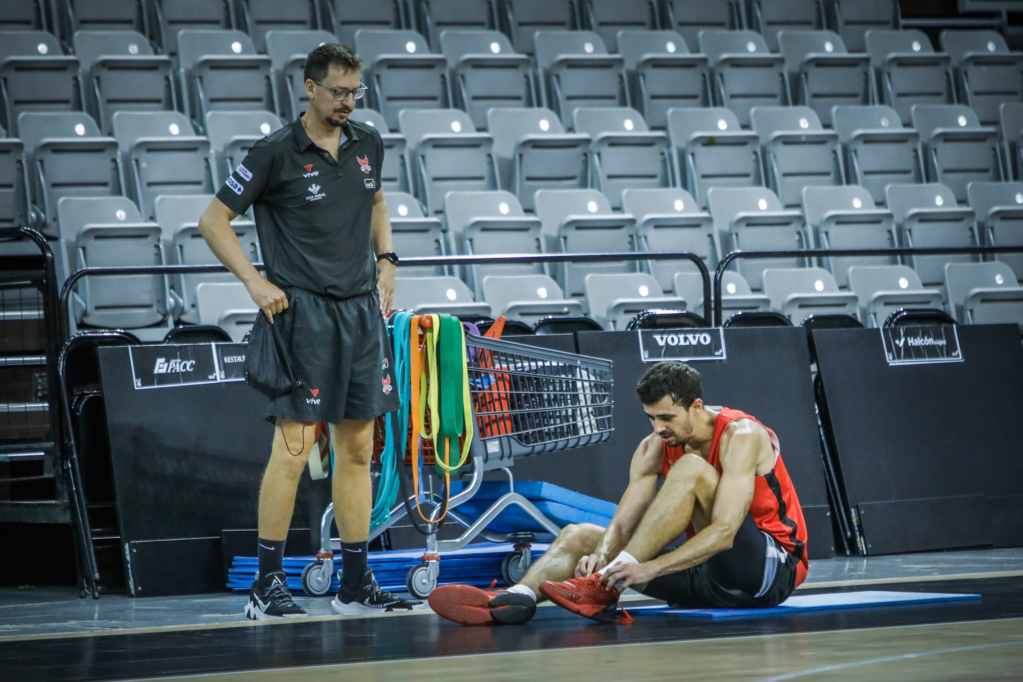 Pere Tomàs se abrocha las zapatillas ante el preparador físico, Sergio Sánchez, 'Pinzas'.