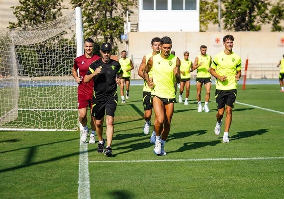 Jugadores del Almería corriendo junto a Manel, uno de los entrenadores. UDA