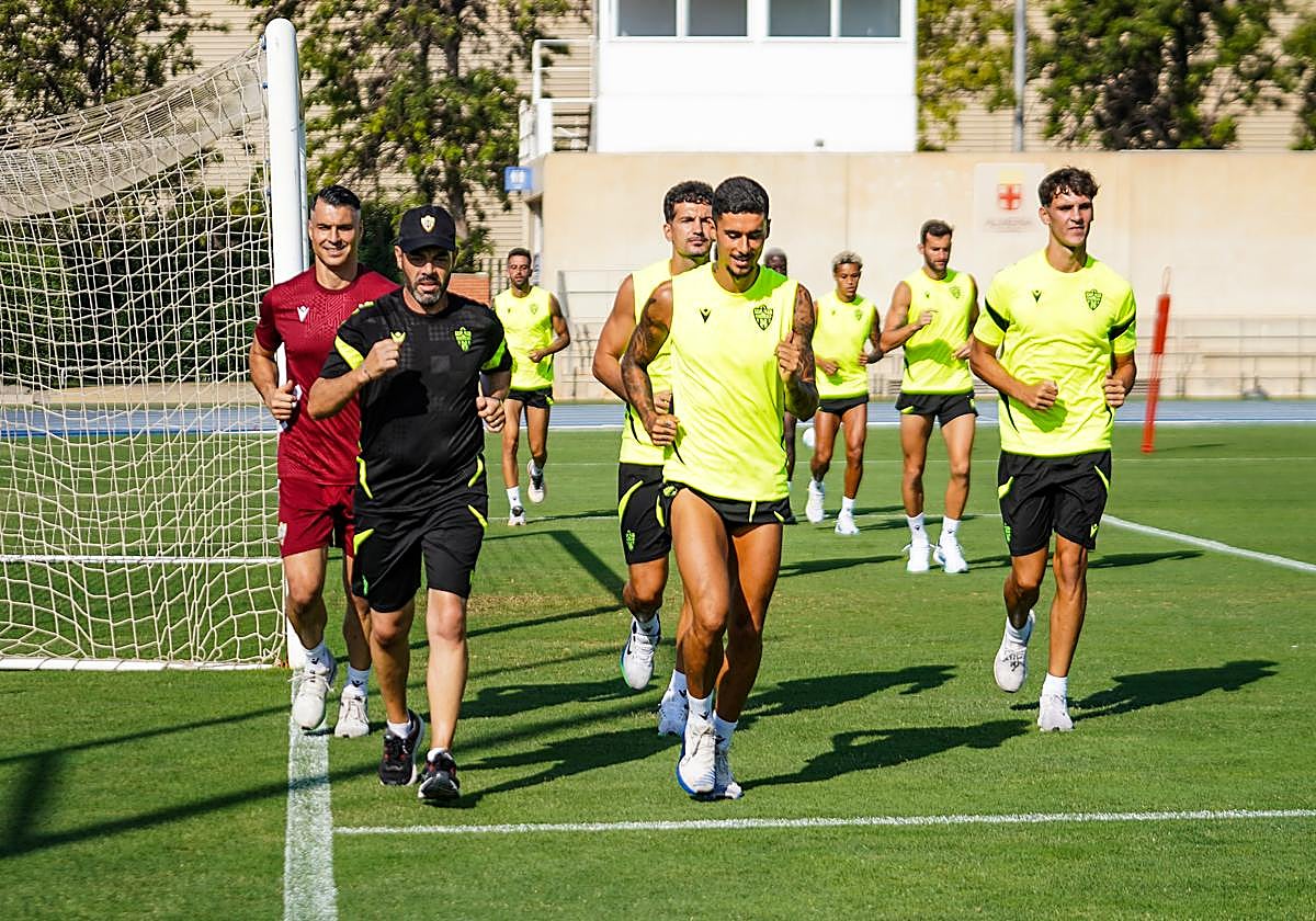 Jugadores del Almería corriendo junto a Manel, uno de los entrenadores. UDA