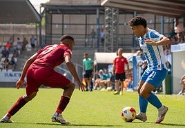 El defensa minero Manny defendiendo el ataque en banda del talaverano Valentín en el amistoso.