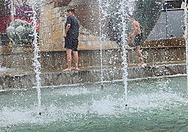Unos jóvenes se refrescan en una de las fuentes de la capital, este verano.
