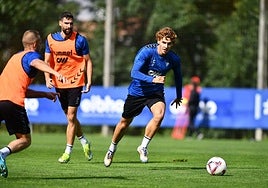 Jorge Pascual conduce el balón en un entrenamiento con el Eibar ante la mirada del exrojiblanco Antonio Puertas.