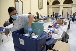 Una enfermera deposita las bolsas de sangre en un contenedor frigorífico.