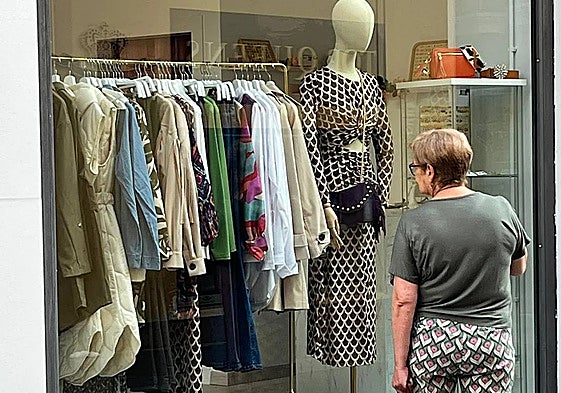 Una viandante contempla el escaparate de un comercio.