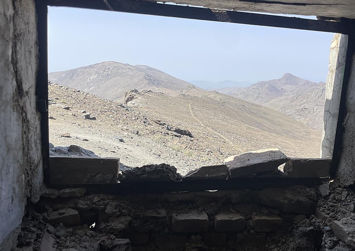 Imagen secundaria 1 - Un excursionista asomado al aljibe del refugio, el pico del Caballo, a través de la ventana, y cascoques en el suelo del albergue. 