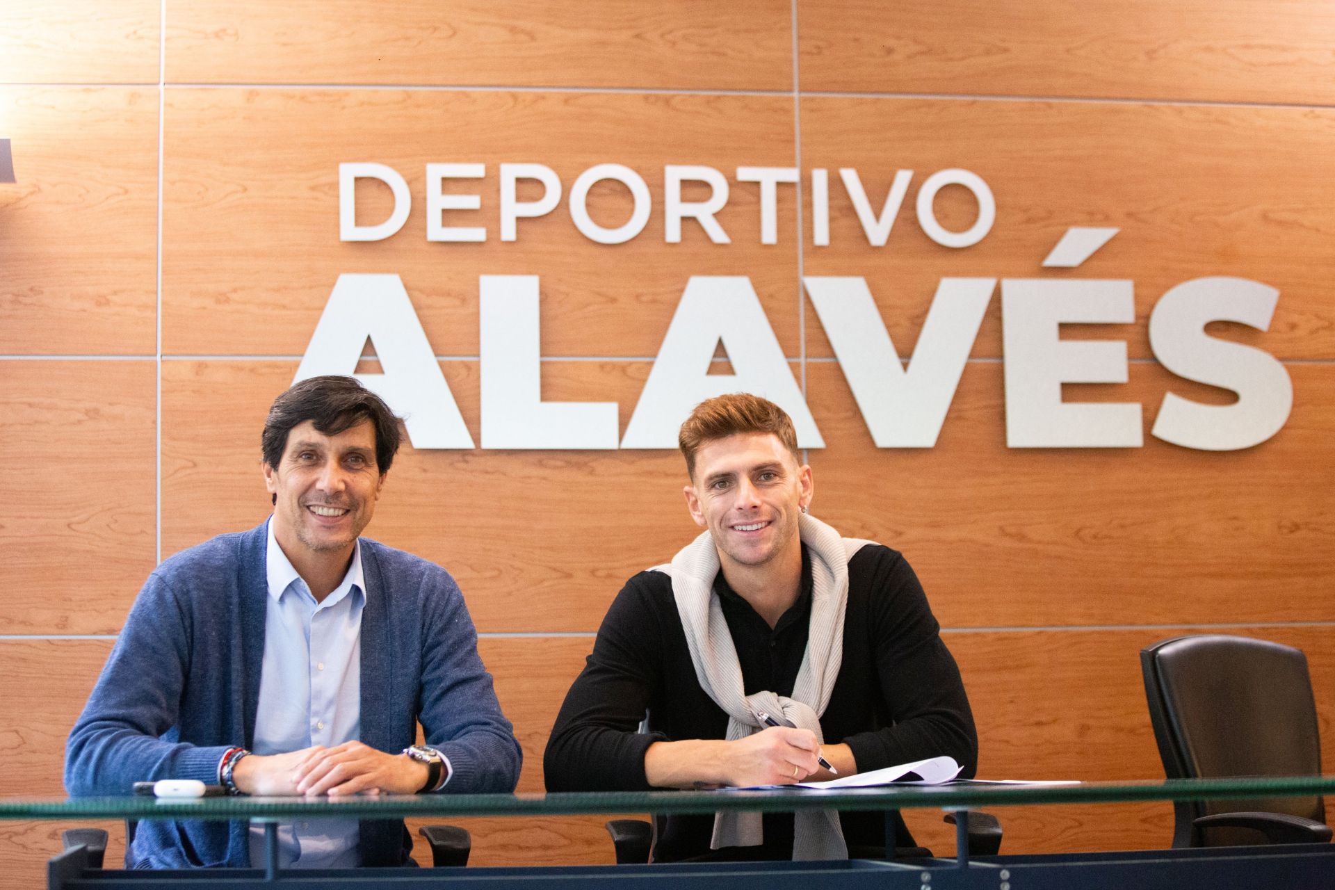 Lucas Boyé firma su contrato con el Alavés junto a su director deportivo, Sergio Fernández.