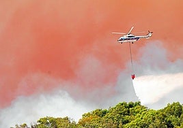 Un helicóptero trabaja en las tareas de extinción del incendio deTarifa.