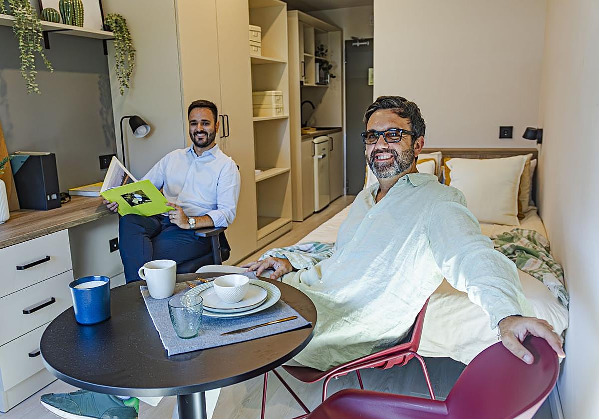 Imagen principal - Juan Bascón y Enrique Molina en una de las habitaciones de Codomo y abajo la terraza con piscina y otra zona común, donde se están ultimando los detalles.