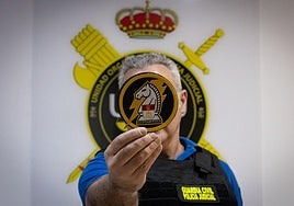 Uno de los dos negociadores de la Guardia Civil sostiene el nuevo escudo, creado recientemente.