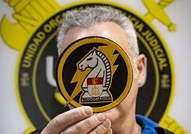 Uno de los dos negociadores de la Guardia Civil sostiene el nuevo escudo, creado recientemente.